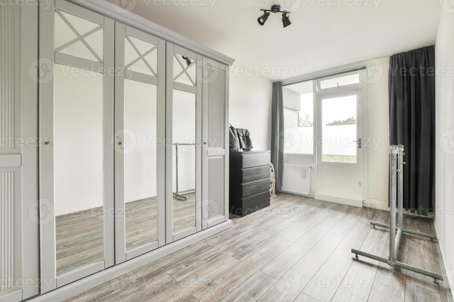 A room with a large closet and mirror photo