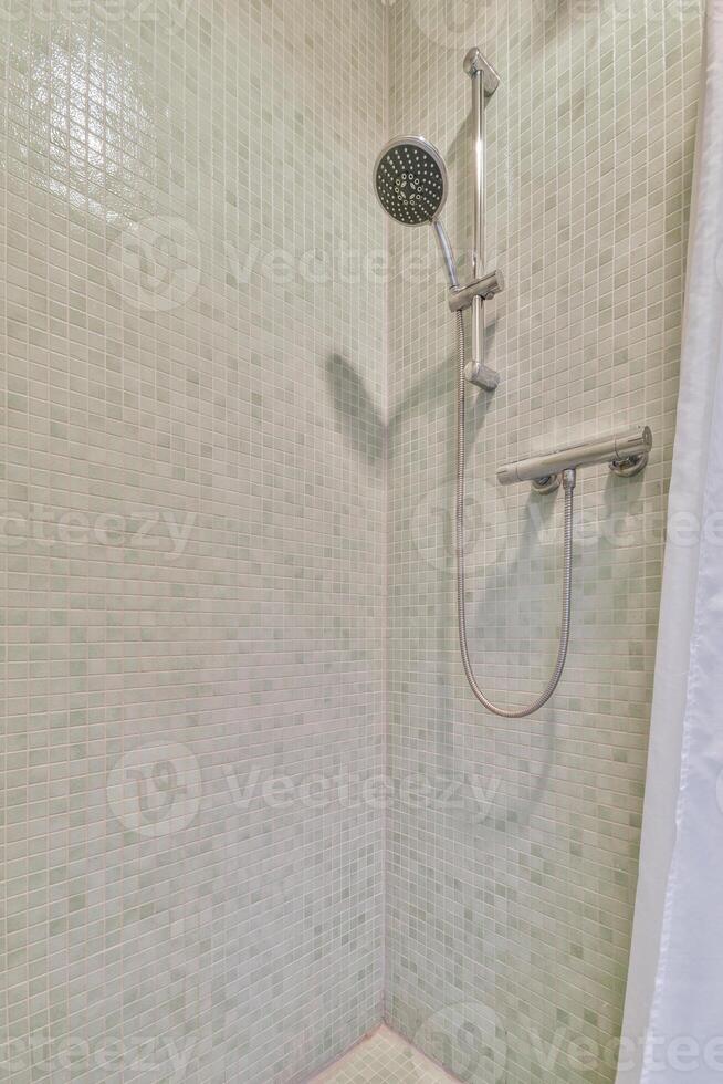 A shower with a shower head and a shower curtain photo
