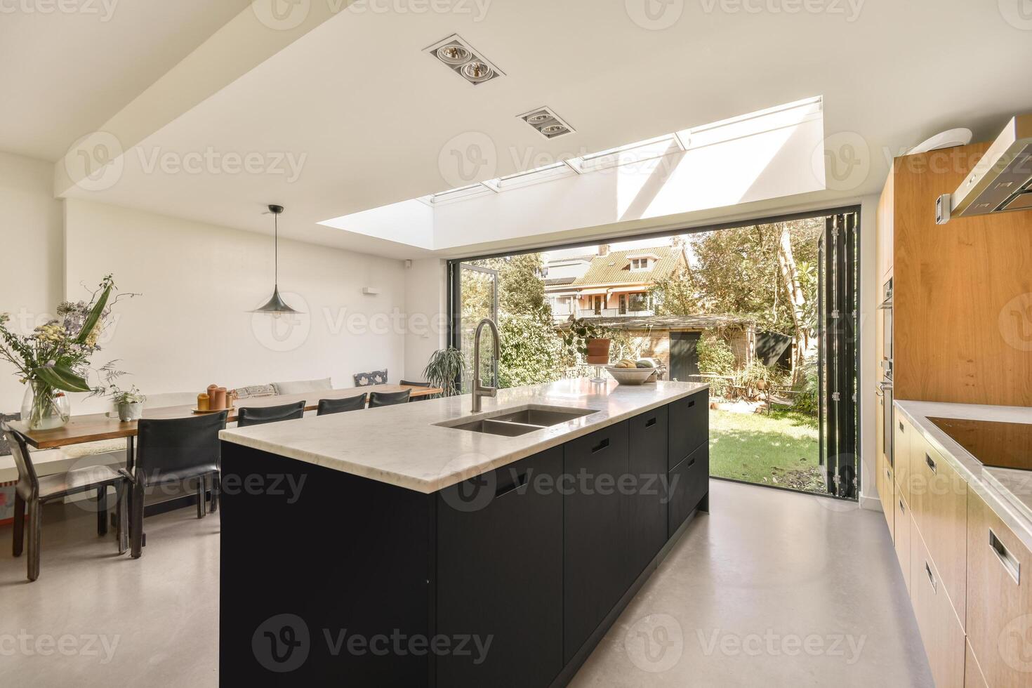 A kitchen with a skylight and a dining table photo