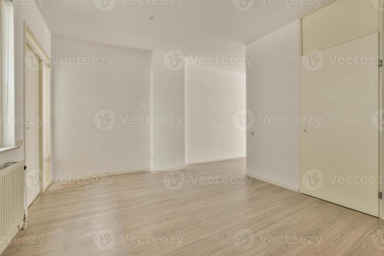 An empty room with white walls and wooden floors photo