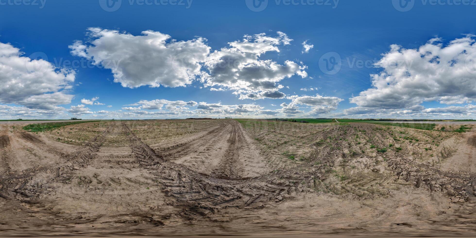 hdri 360 panorama on dirt muddy road among fields in spring day with clouds in equirectangular full seamless spherical projection, for VR AR virtual reality content photo