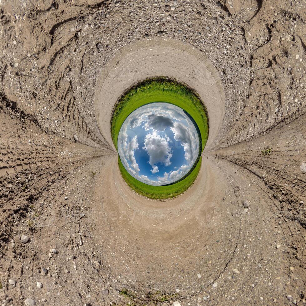 blue hole sphere or globe little planet inside sand or dry ground frame background with tractor tracks photo