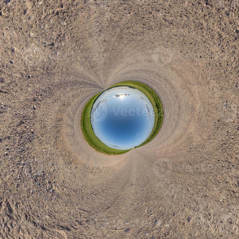 blue hole sphere or globe little planet inside sand or dry ground frame background with tractor tracks photo