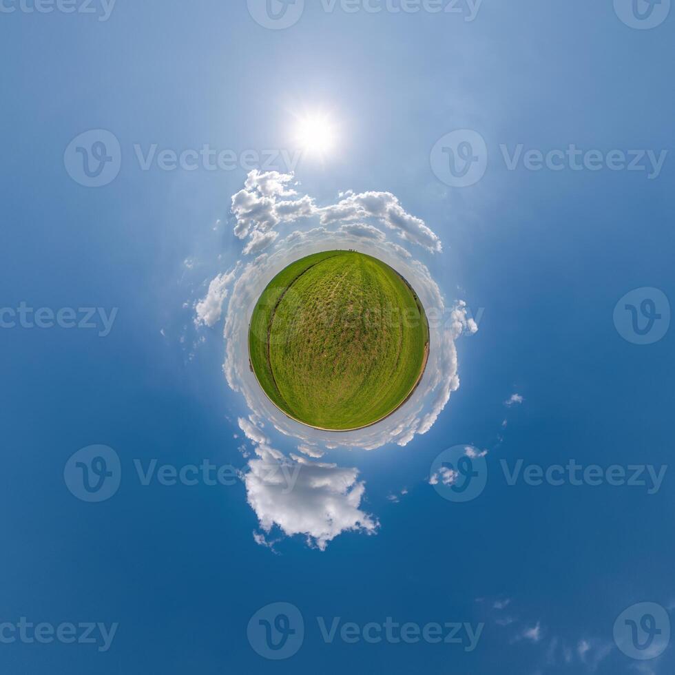 simple little tiny planet without buildings in blue sky with beautiful clouds. Transformation of spherical panorama 360 degrees. Spherical abstract aerial view. Curvature of space. photo