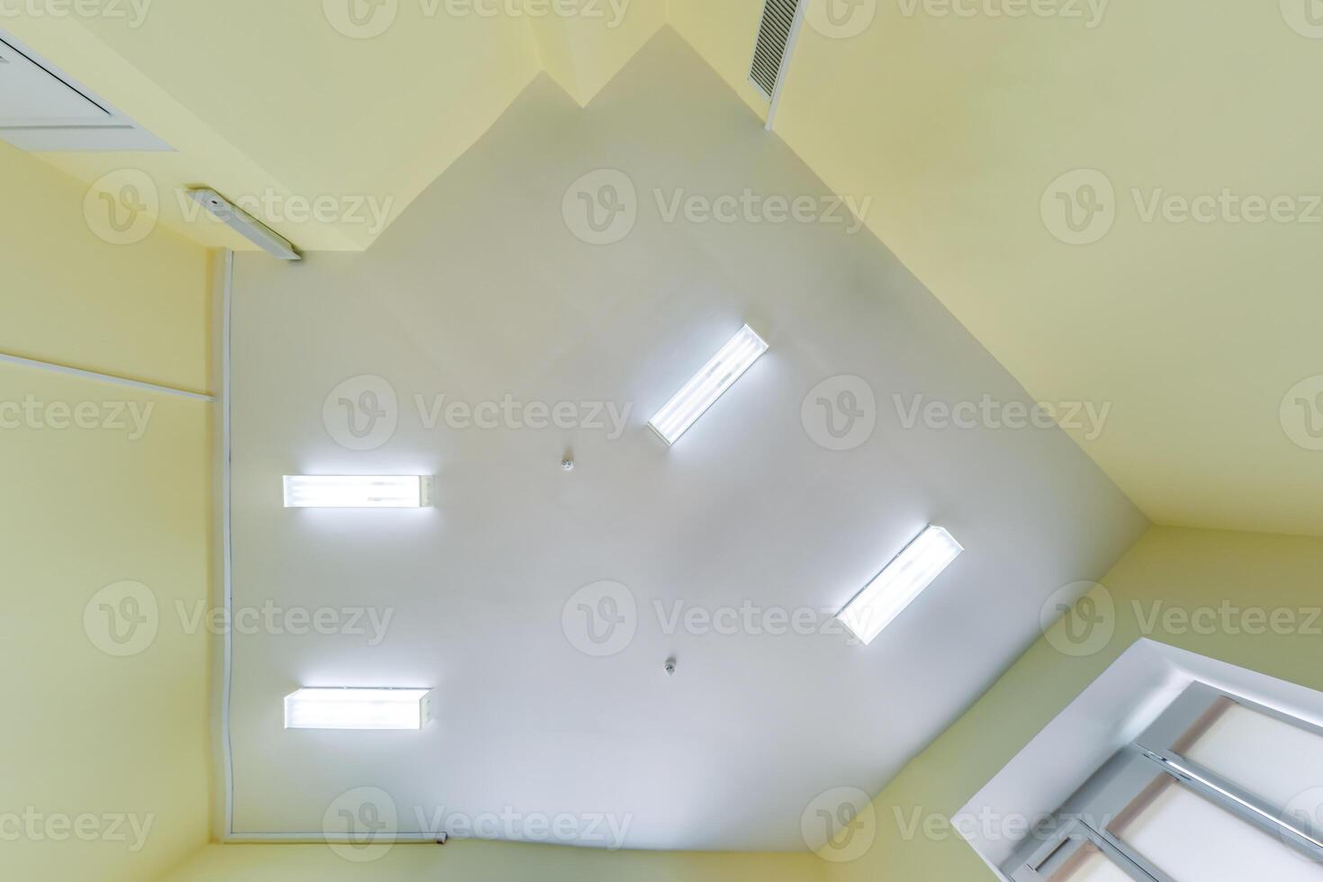 ceiling with vintage halogen spots lamps and drywall construction in empty room in house or office. Looking up view photo