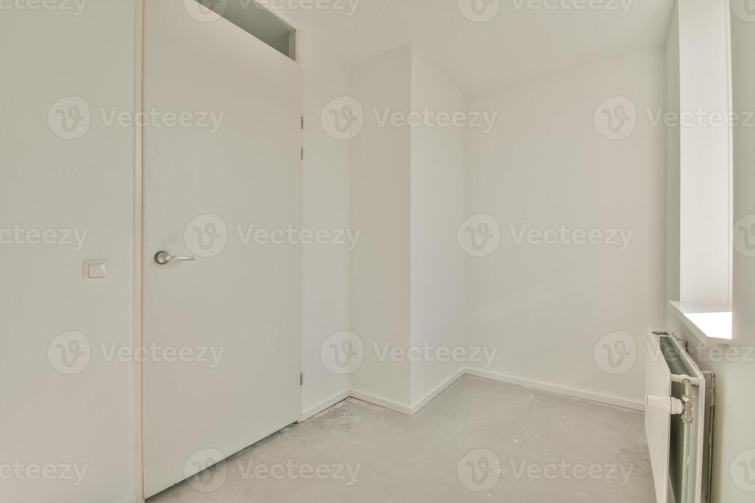 A white room with a door and a radiator photo
