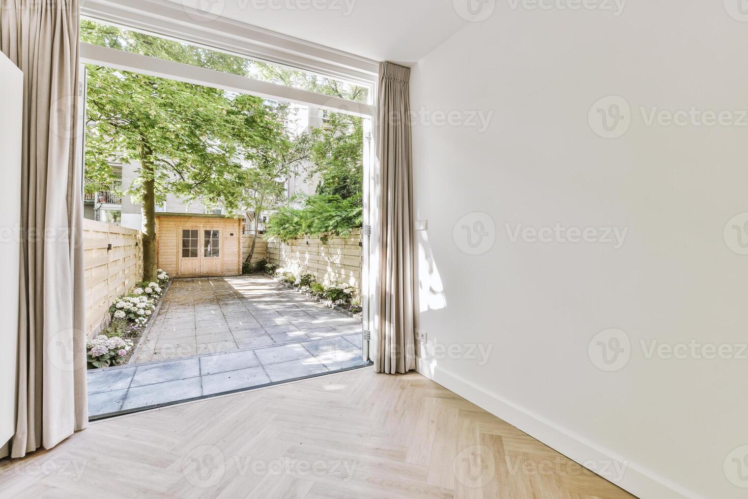 A room with a door and a window with a tree in the background photo