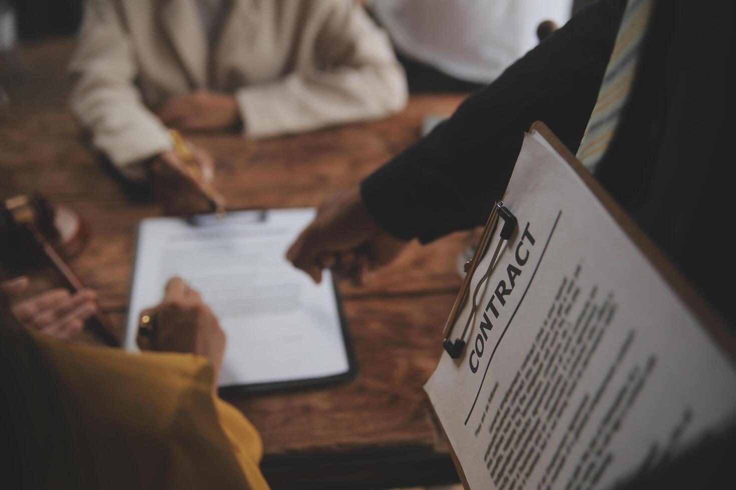 Business and lawyers discussing contract papers with brass scale on desk in office. Law, legal services, advice, justice and law concept picture with film grain effect photo