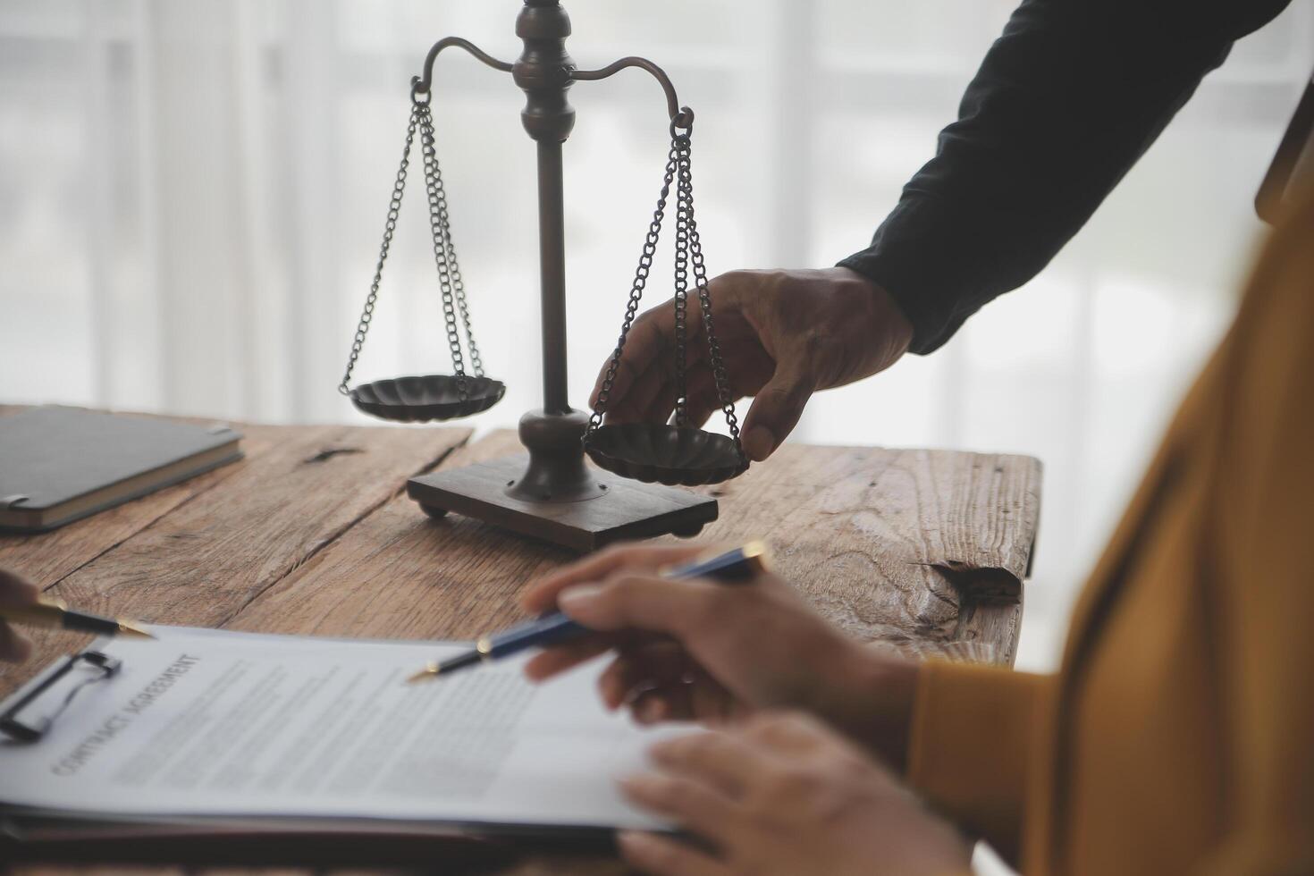 Business and lawyers discussing contract papers with brass scale on desk in office. Law, legal services, advice, justice and law concept picture with film grain effect photo