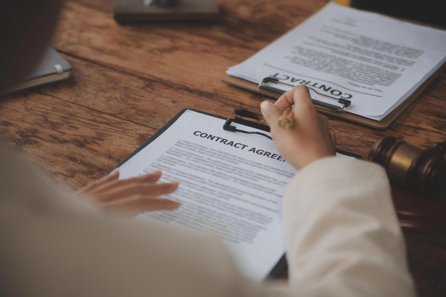 Business and lawyers discussing contract papers with brass scale on desk in office. Law, legal services, advice, justice and law concept picture with film grain effect photo