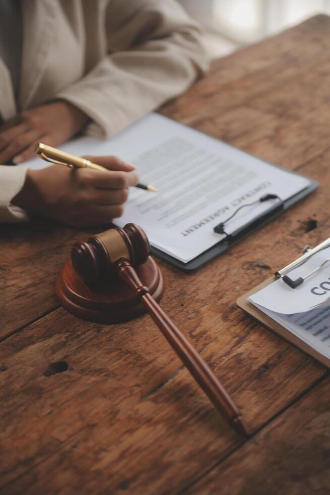 Business and lawyers discussing contract papers with brass scale on desk in office. Law, legal services, advice, justice and law concept picture with film grain effect photo