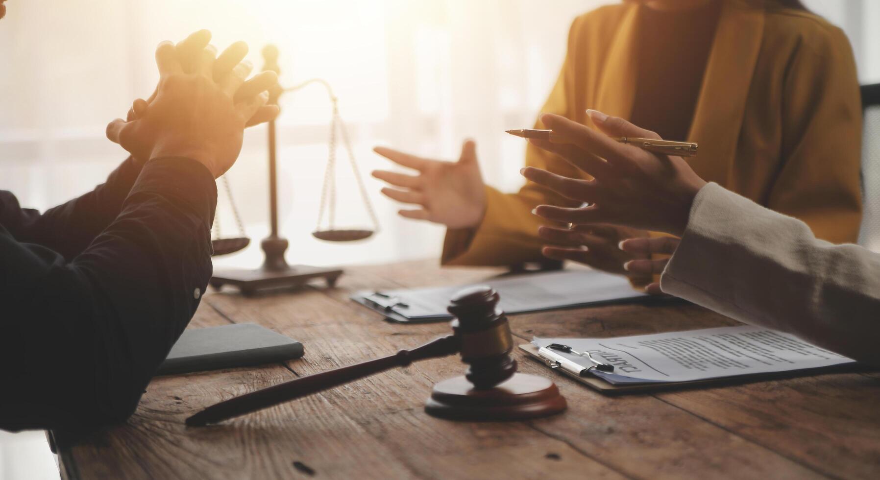 Business and lawyers discussing contract papers with brass scale on desk in office. Law, legal services, advice, justice and law concept picture with film grain effect photo