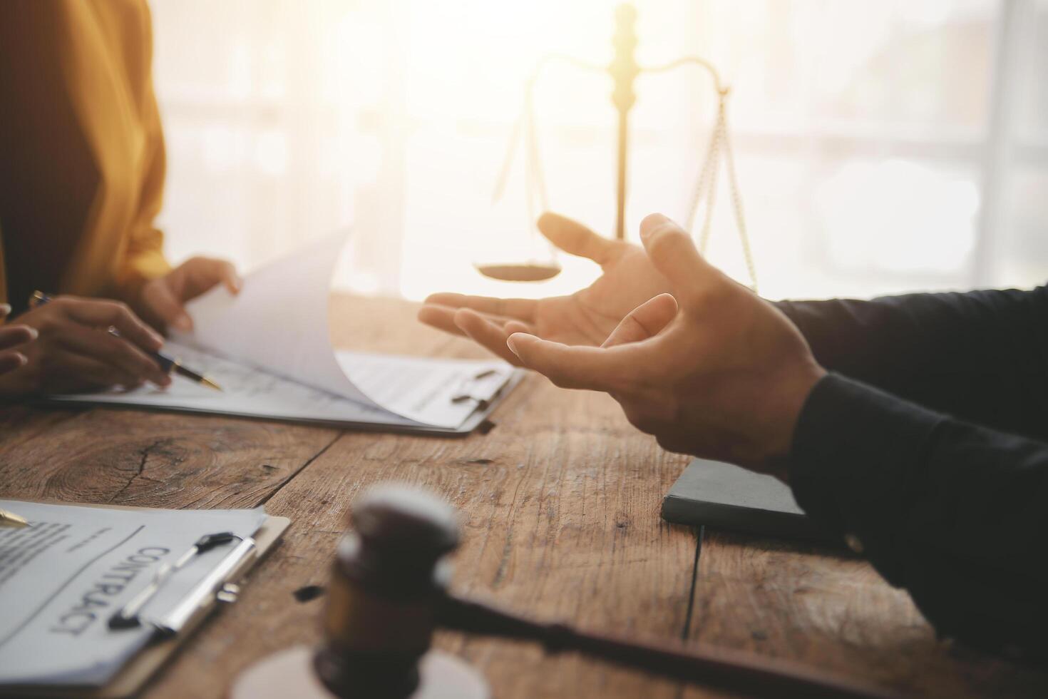 Business and lawyers discussing contract papers with brass scale on desk in office. Law, legal services, advice, justice and law concept picture with film grain effect photo