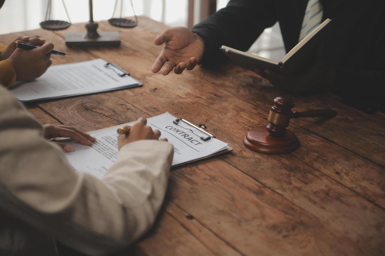 Business and lawyers discussing contract papers with brass scale on desk in office. Law, legal services, advice, justice and law concept picture with film grain effect photo