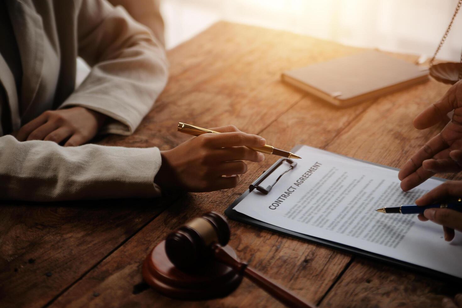 Business and lawyers discussing contract papers with brass scale on desk in office. Law, legal services, advice, justice and law concept picture with film grain effect photo