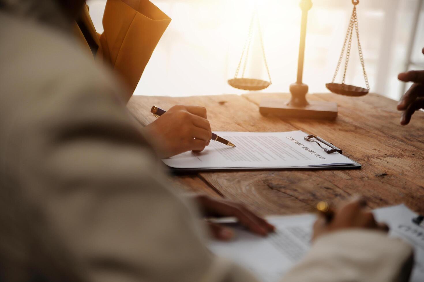 Business and lawyers discussing contract papers with brass scale on desk in office. Law, legal services, advice, justice and law concept picture with film grain effect photo