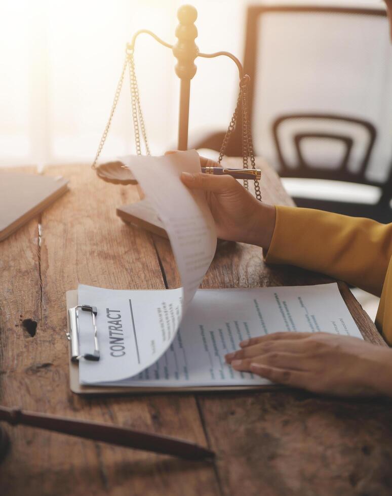 Business and lawyers discussing contract papers with brass scale on desk in office. Law, legal services, advice, justice and law concept picture with film grain effect photo