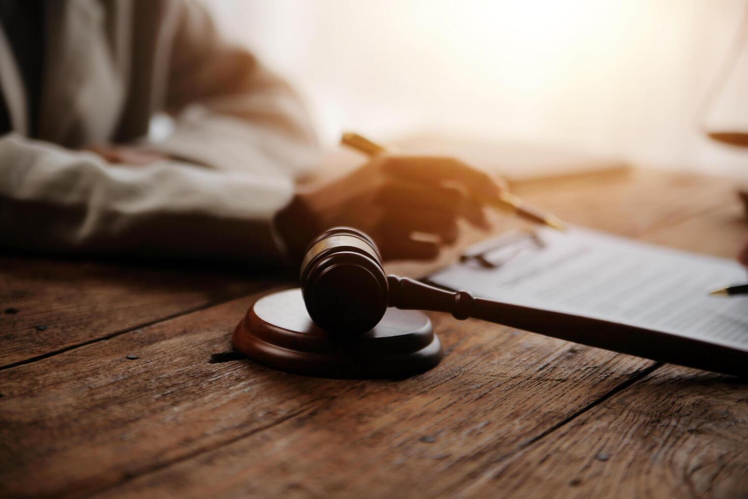 Business and lawyers discussing contract papers with brass scale on desk in office. Law, legal services, advice, justice and law concept picture with film grain effect photo