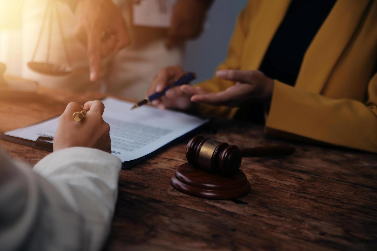 Business and lawyers discussing contract papers with brass scale on desk in office. Law, legal services, advice, justice and law concept picture with film grain effect photo