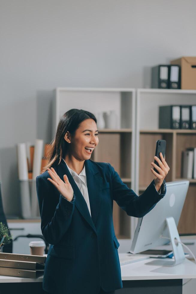 Young asian business woman in suit talking on smart phone isolated on white background, businesswoman speaking on smartphone with conversation, female holding cell phone, communication concept. photo