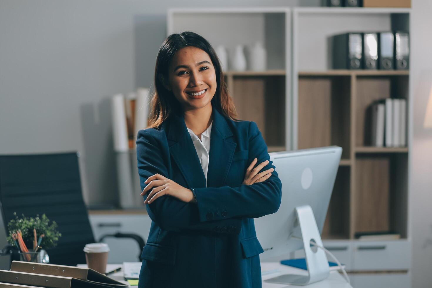 Portrait of Happy young Asian businesswoman looking at camera,arms crossed folded.Smiling woman executive manager,secretary offering professional business services standing in office. photo
