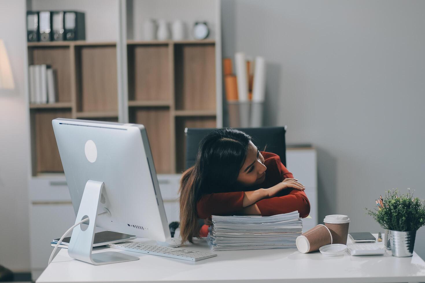 The business lady and the employee take a nap while working on the office desk. Working women are exhausted and sleeping on the table photo