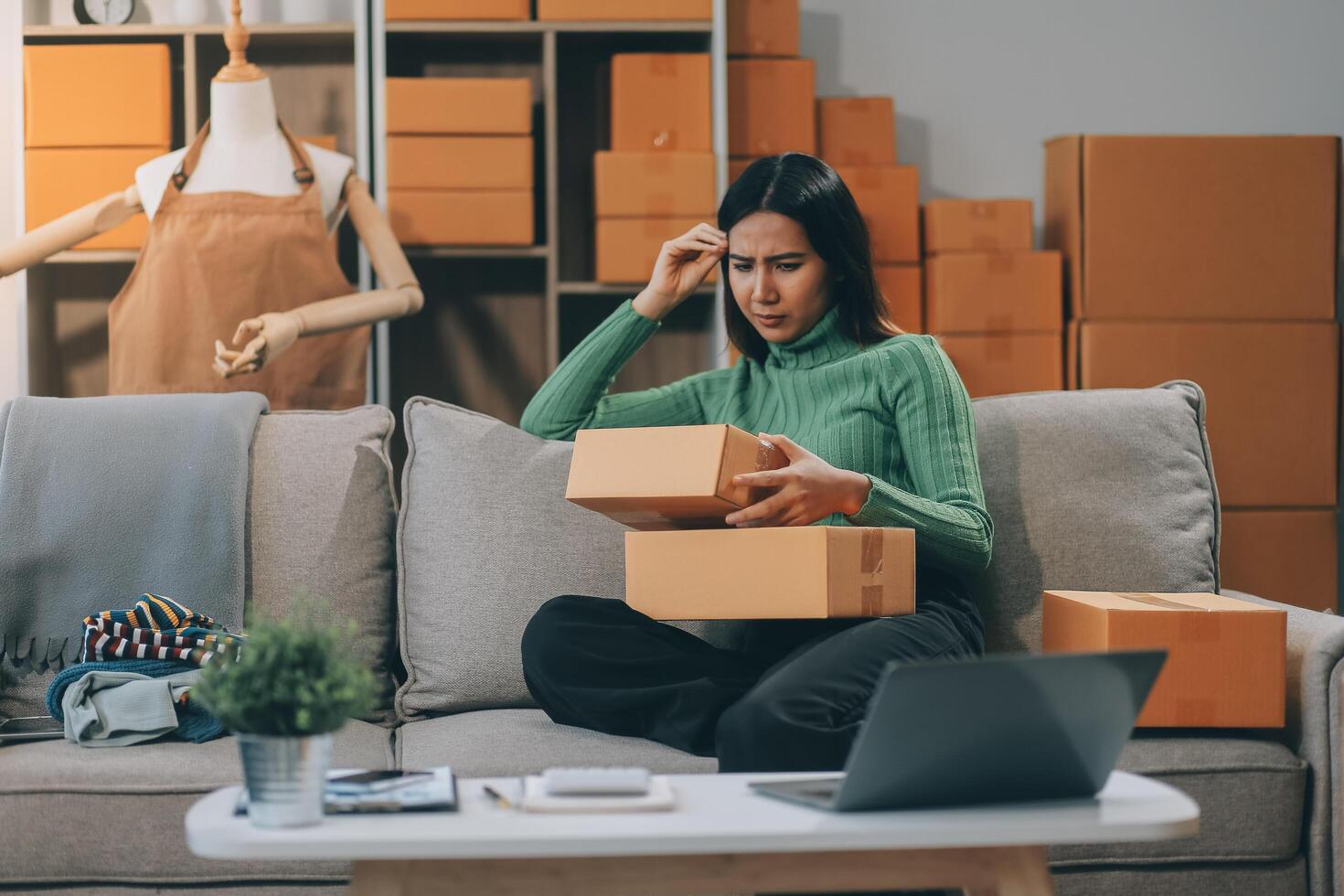 Asian SME business women use laptop computer checking customer order online shipping boxes at home. Starting Small business entrepreneur SME freelance. Online business, Work at home concept. photo