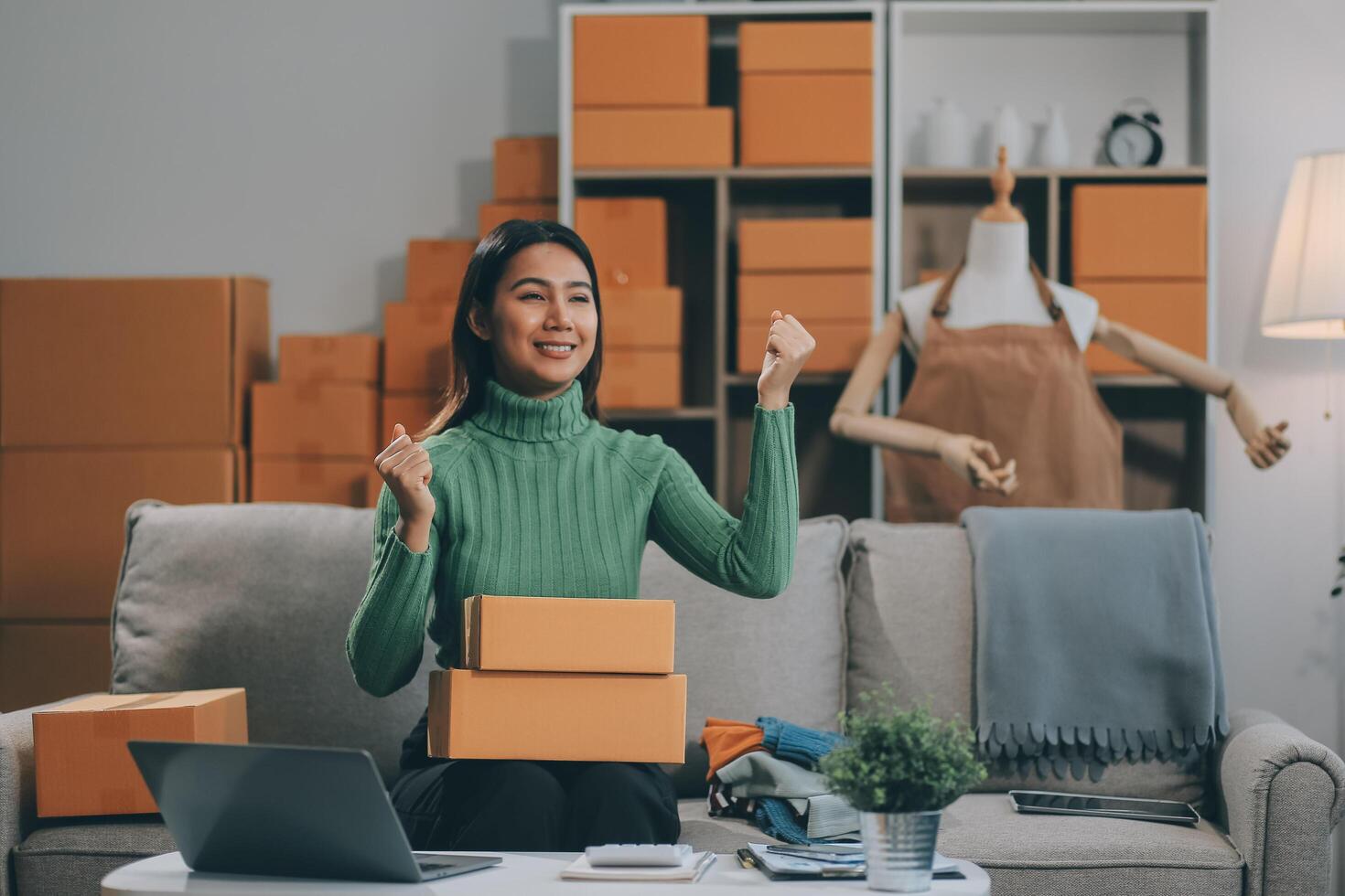 Asian SME business women use laptop computer checking customer order online shipping boxes at home. Starting Small business entrepreneur SME freelance. Online business, Work at home concept. photo