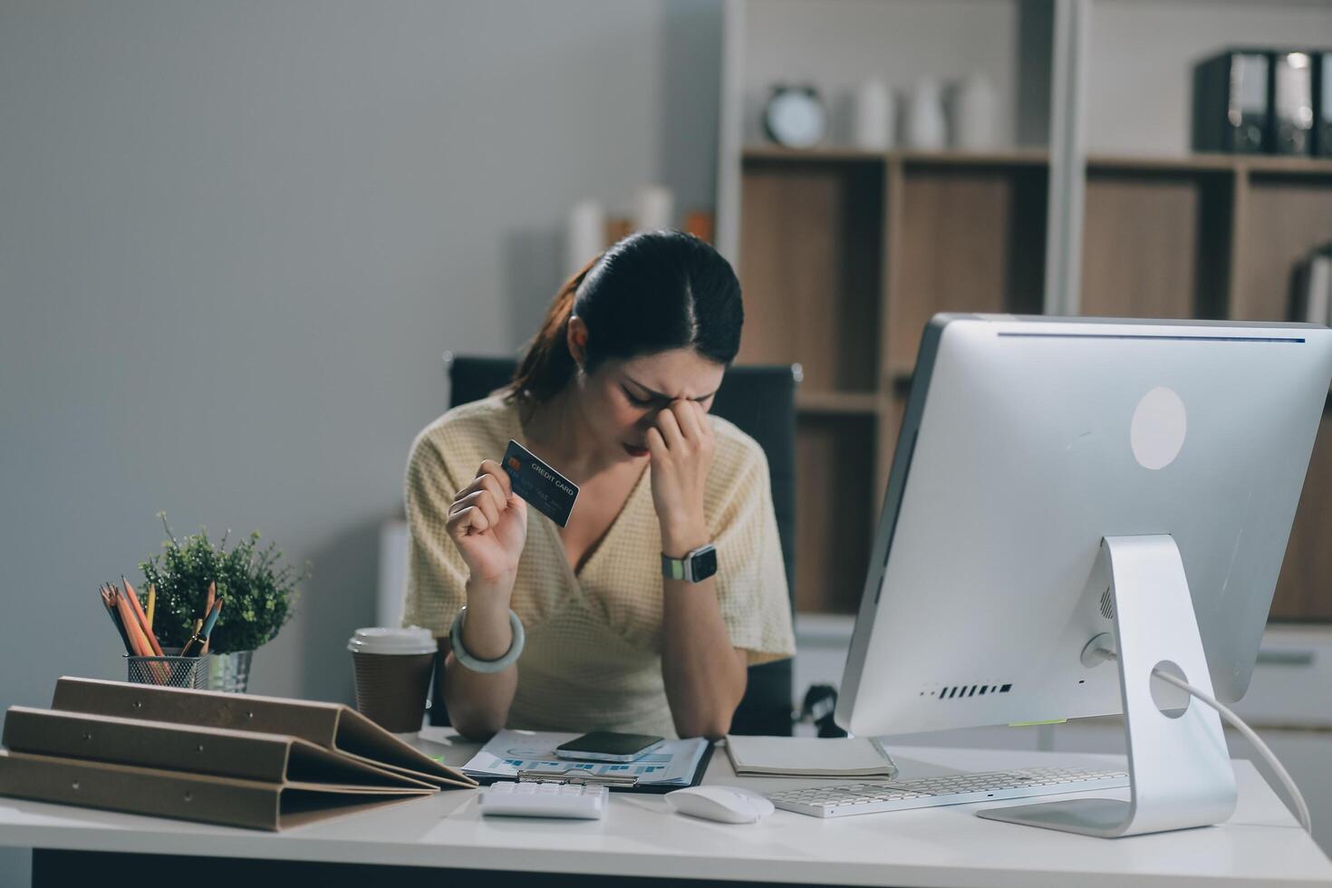 Unhappy and dissatisfied young Asian female office employee contacts a credit card call-center service to inform them of the problems. photo