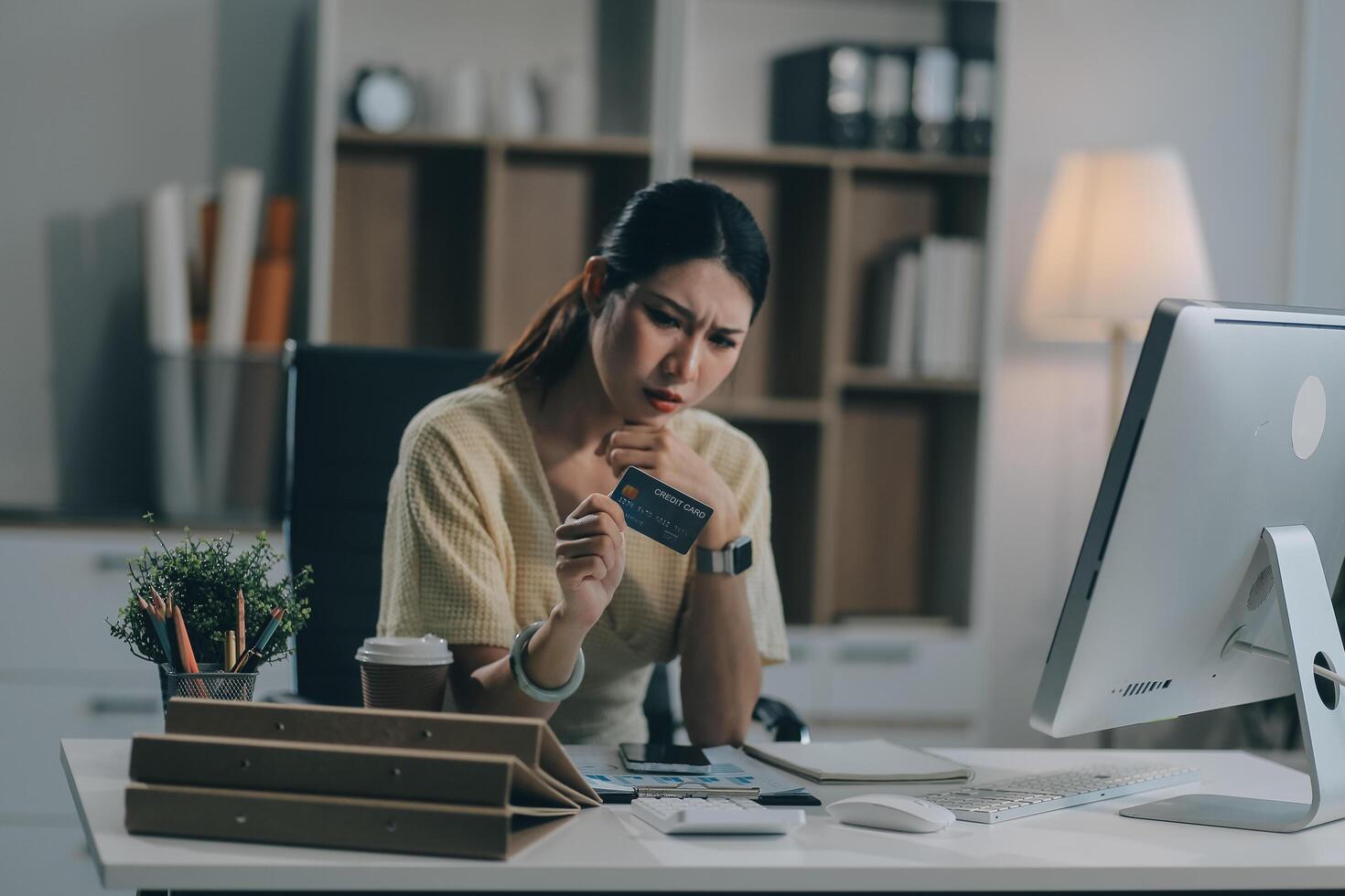 Unhappy and dissatisfied young Asian female office employee contacts a credit card call-center service to inform them of the problems. photo