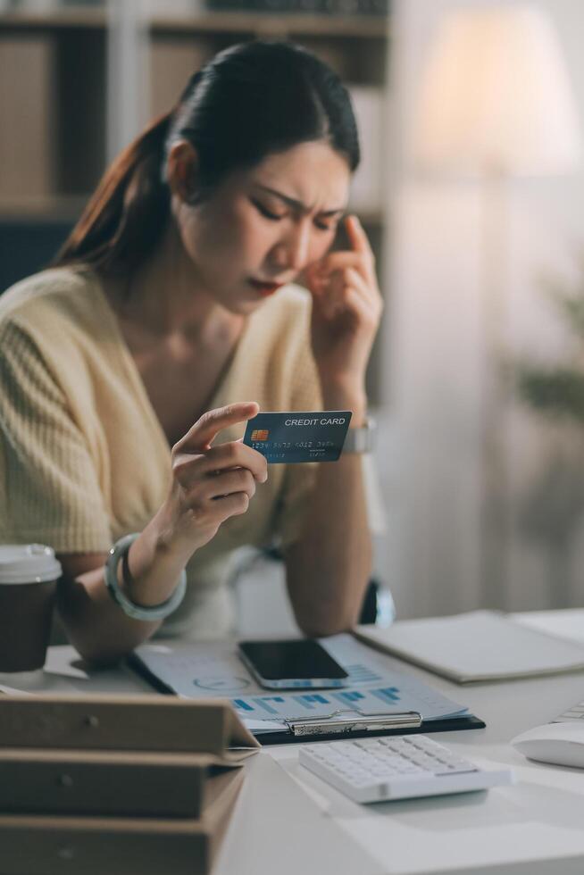Unhappy and dissatisfied young Asian female office employee contacts a credit card call-center service to inform them of the problems. photo