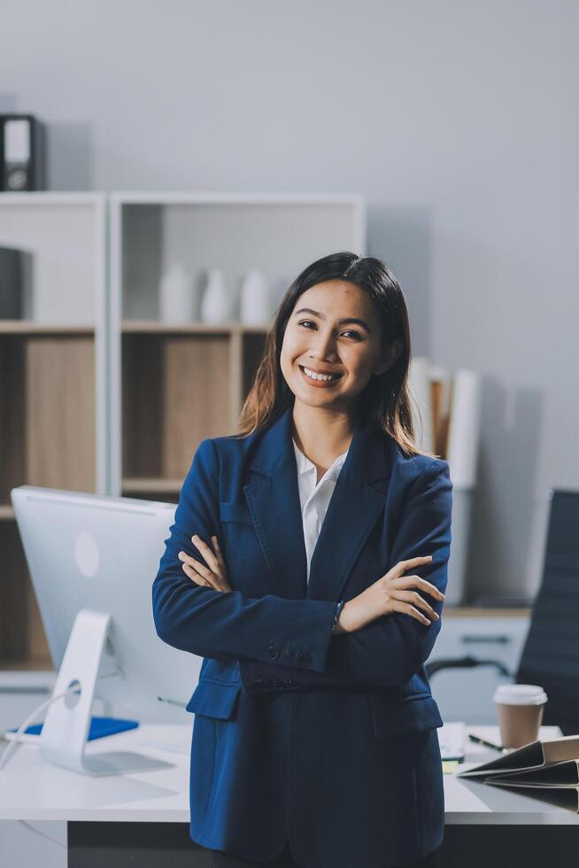 Portrait of Happy young Asian businesswoman looking at camera,arms crossed folded.Smiling woman executive manager,secretary offering professional business services standing in office. photo