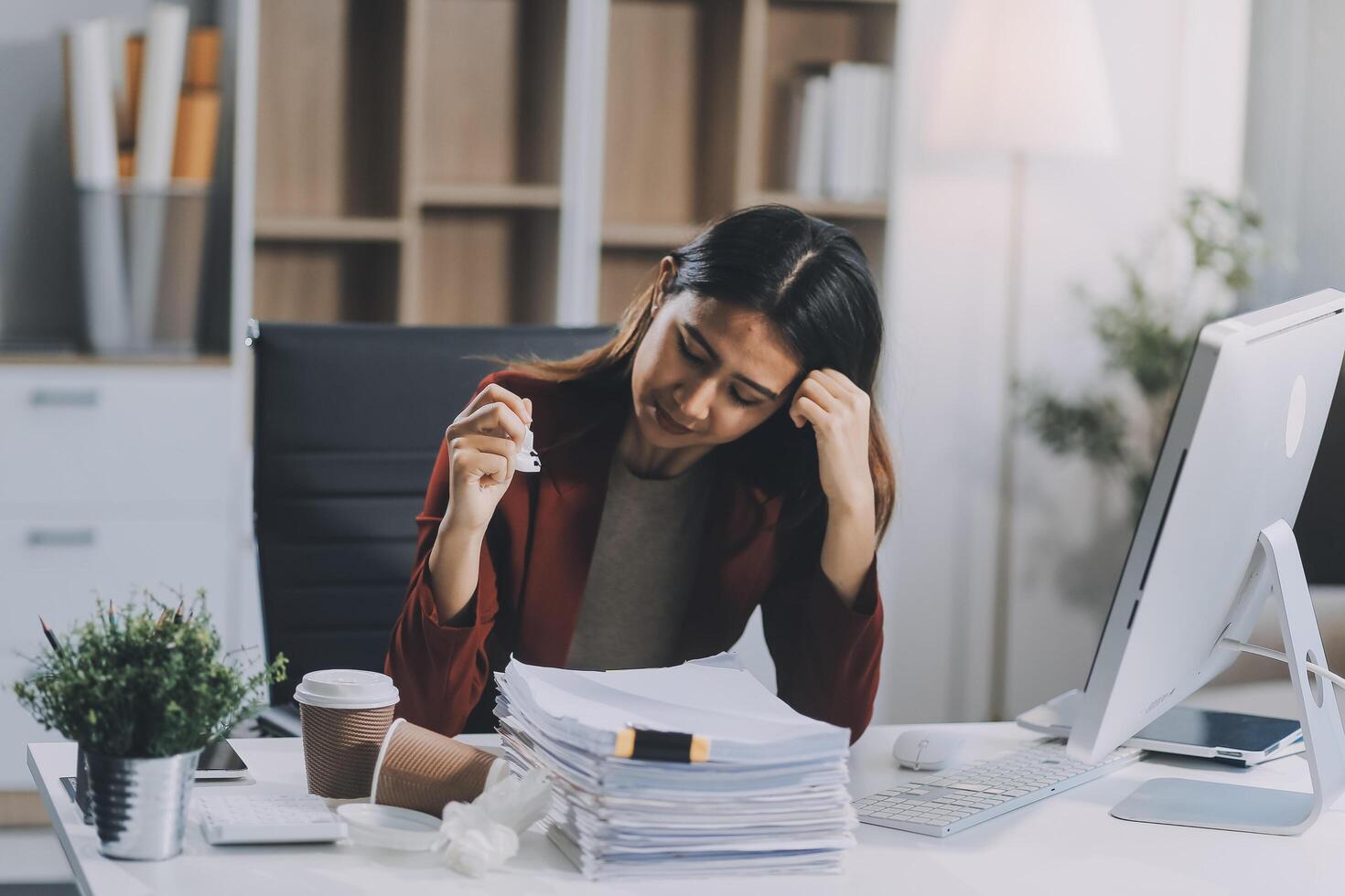 Young asian business woman with tired eyes and headache photo