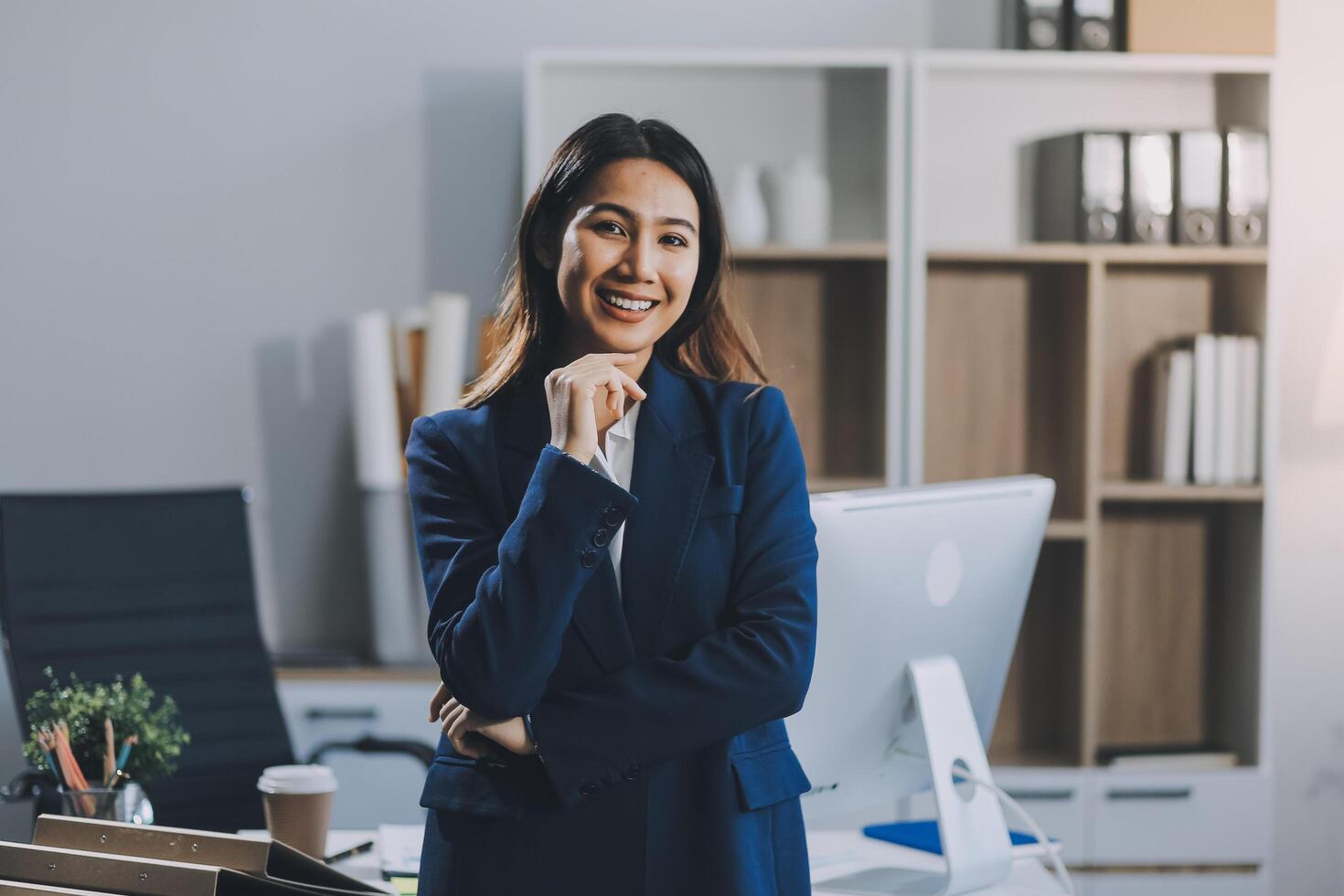 Portrait of Happy young Asian businesswoman looking at camera,arms crossed folded.Smiling woman executive manager,secretary offering professional business services standing in office. photo
