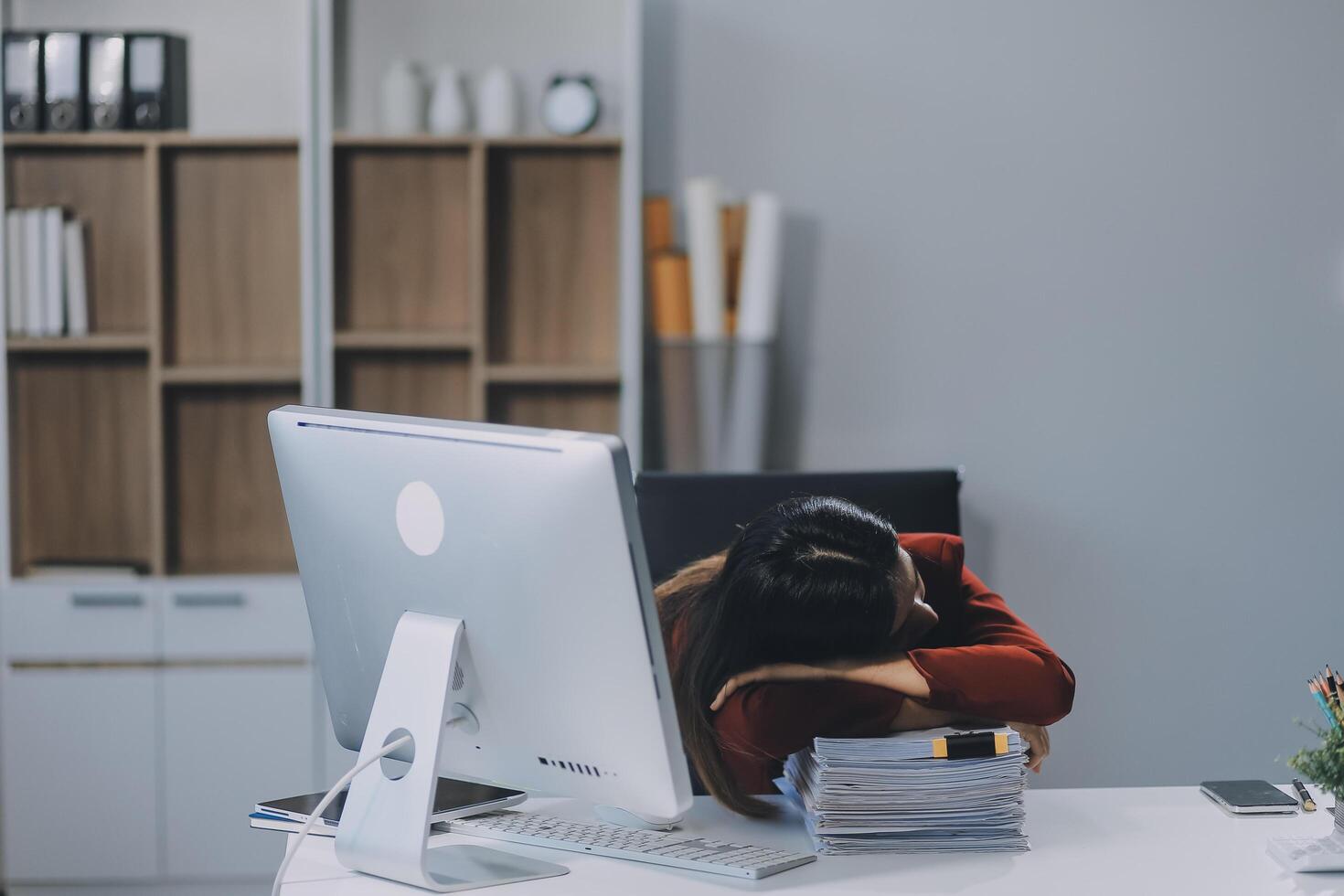 The business lady and the employee take a nap while working on the office desk. Working women are exhausted and sleeping on the table photo