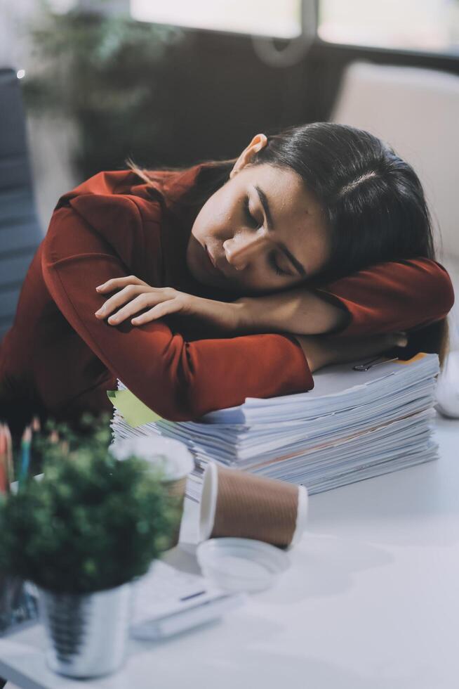 The business lady and the employee take a nap while working on the office desk. Working women are exhausted and sleeping on the table photo