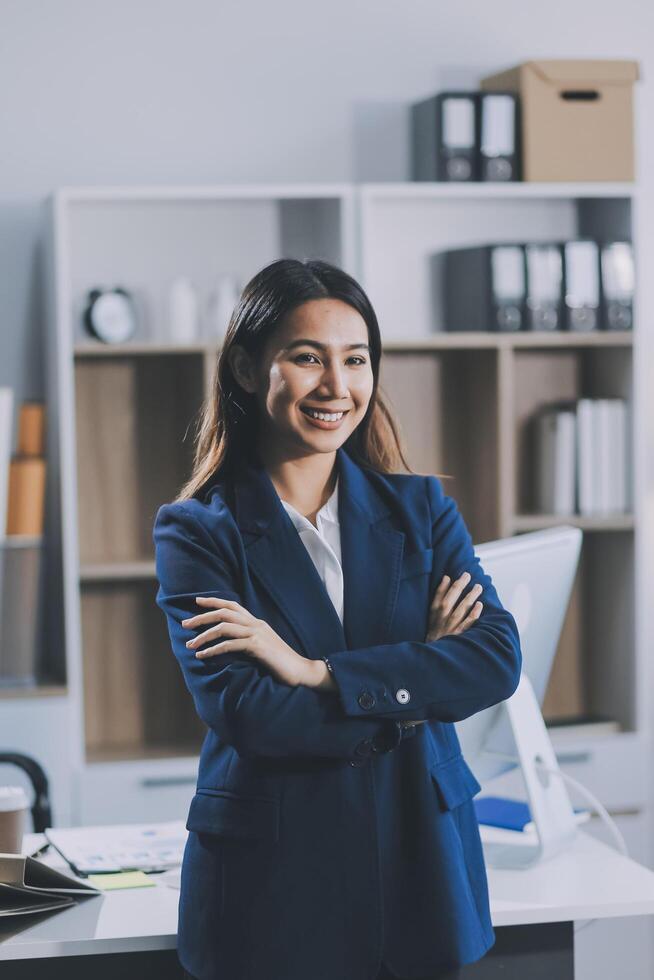 Portrait of Happy young Asian businesswoman looking at camera,arms crossed folded.Smiling woman executive manager,secretary offering professional business services standing in office. photo