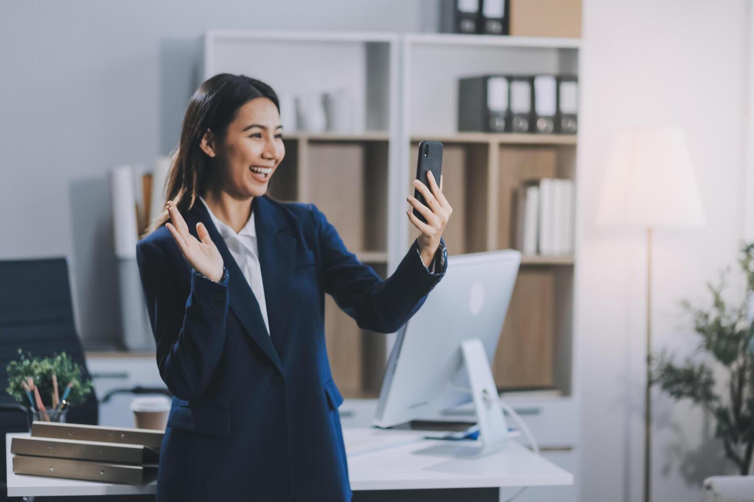 Young asian business woman in suit talking on smart phone isolated on white background, businesswoman speaking on smartphone with conversation, female holding cell phone, communication concept. photo