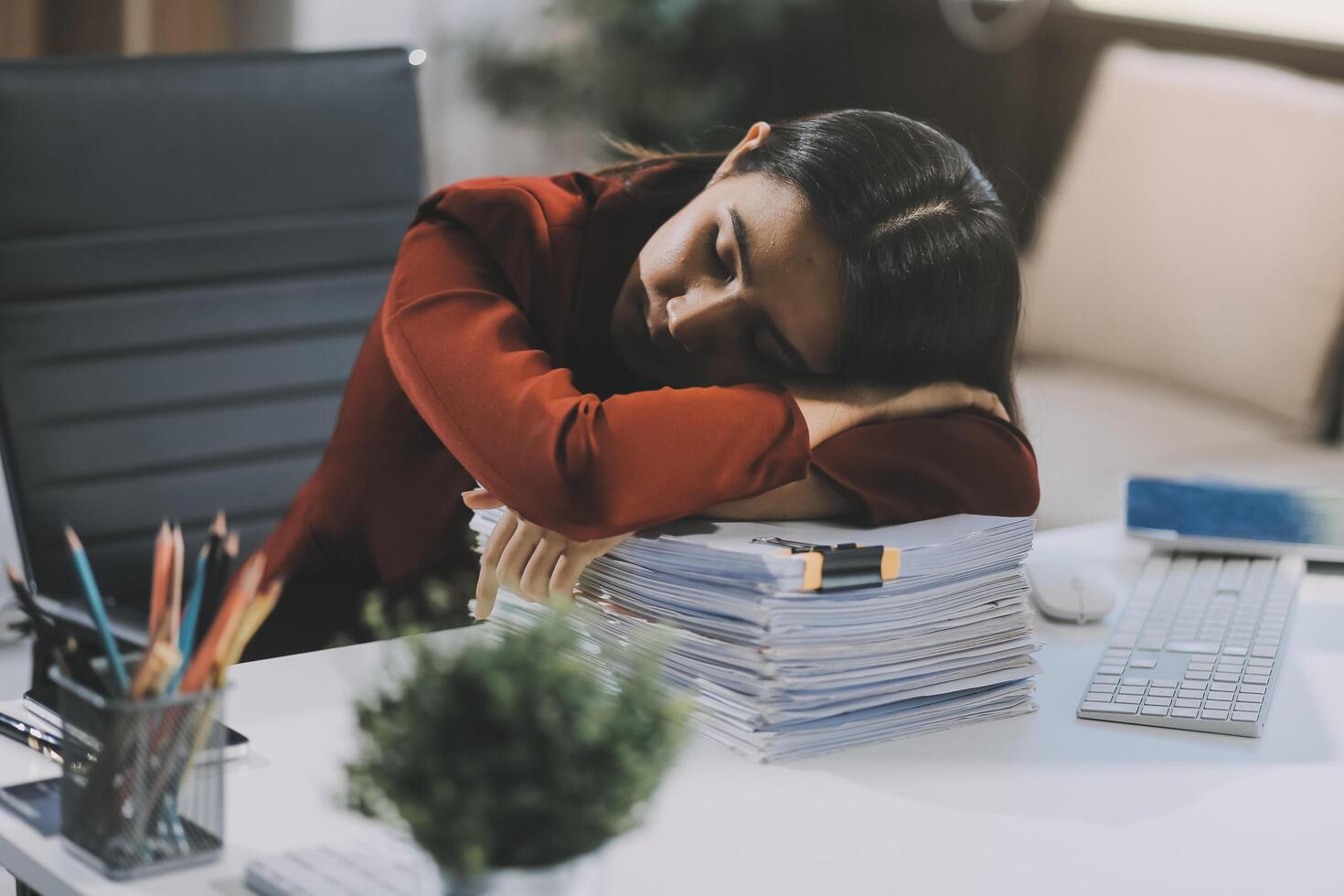 The business lady and the employee take a nap while working on the office desk. Working women are exhausted and sleeping on the table photo