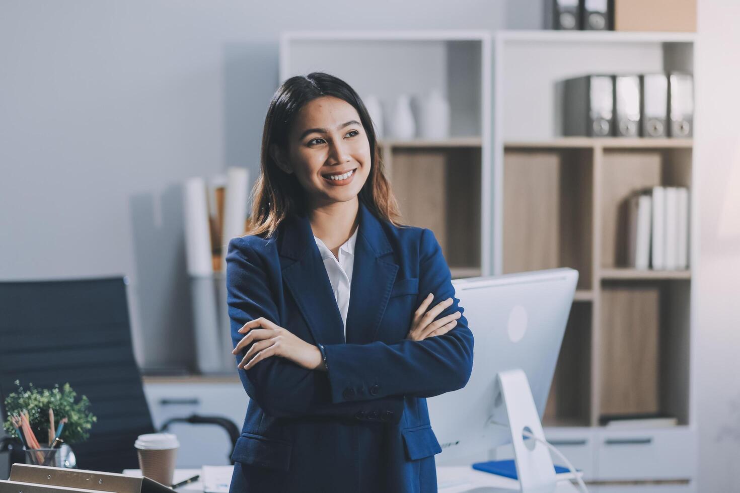 Portrait of Happy young Asian businesswoman looking at camera,arms crossed folded.Smiling woman executive manager,secretary offering professional business services standing in office. photo