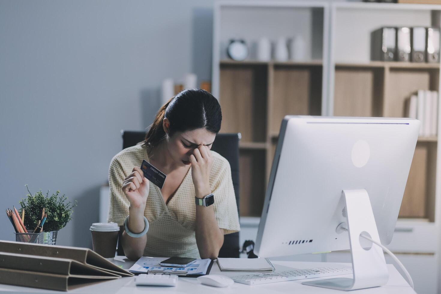 Unhappy and dissatisfied young Asian female office employee contacts a credit card call-center service to inform them of the problems. photo