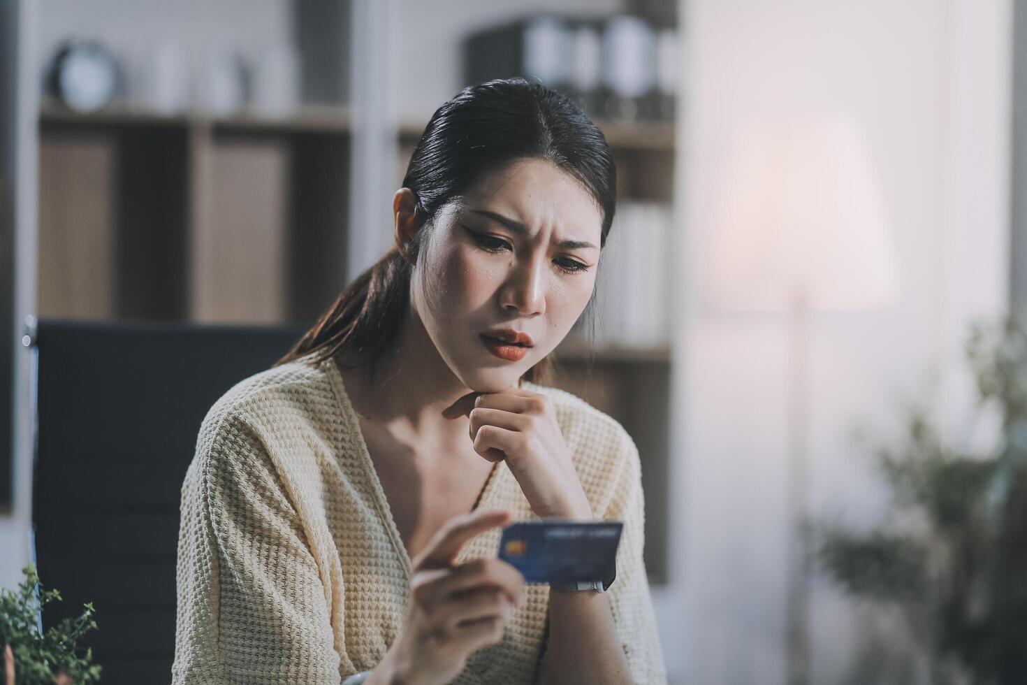 Unhappy and dissatisfied young Asian female office employee contacts a credit card call-center service to inform them of the problems. photo