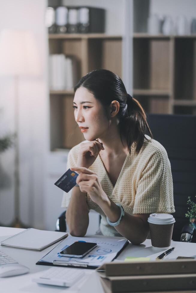 Unhappy and dissatisfied young Asian female office employee contacts a credit card call-center service to inform them of the problems. photo