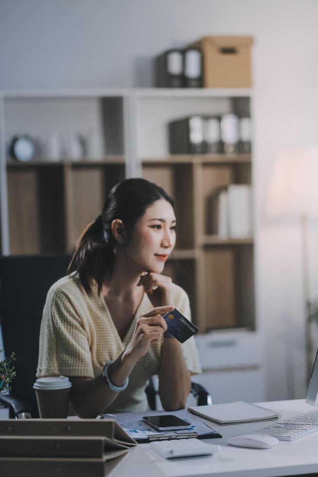 Unhappy and dissatisfied young Asian female office employee contacts a credit card call-center service to inform them of the problems. photo