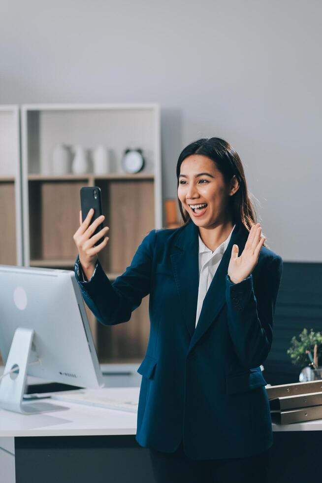 Young asian business woman in suit talking on smart phone isolated on white background, businesswoman speaking on smartphone with conversation, female holding cell phone, communication concept. photo