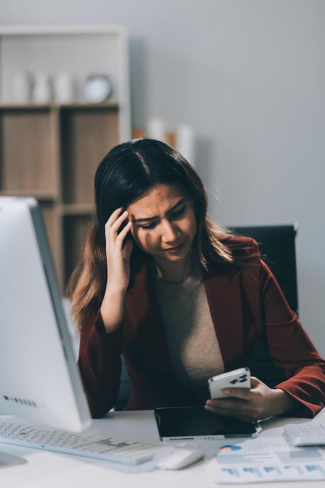 Asian women are stressed while working on laptop, Tired asian businesswoman with headache at office, feeling sick at work, copy space photo