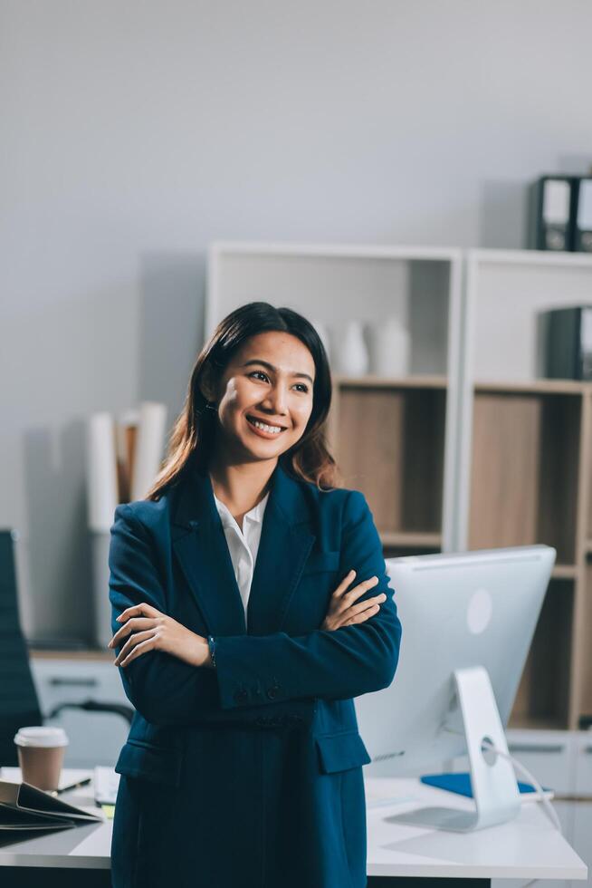 Portrait of Happy young Asian businesswoman looking at camera,arms crossed folded.Smiling woman executive manager,secretary offering professional business services standing in office. photo