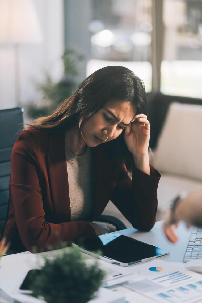 Asian women are stressed while working on laptop, Tired asian businesswoman with headache at office, feeling sick at work, copy space photo