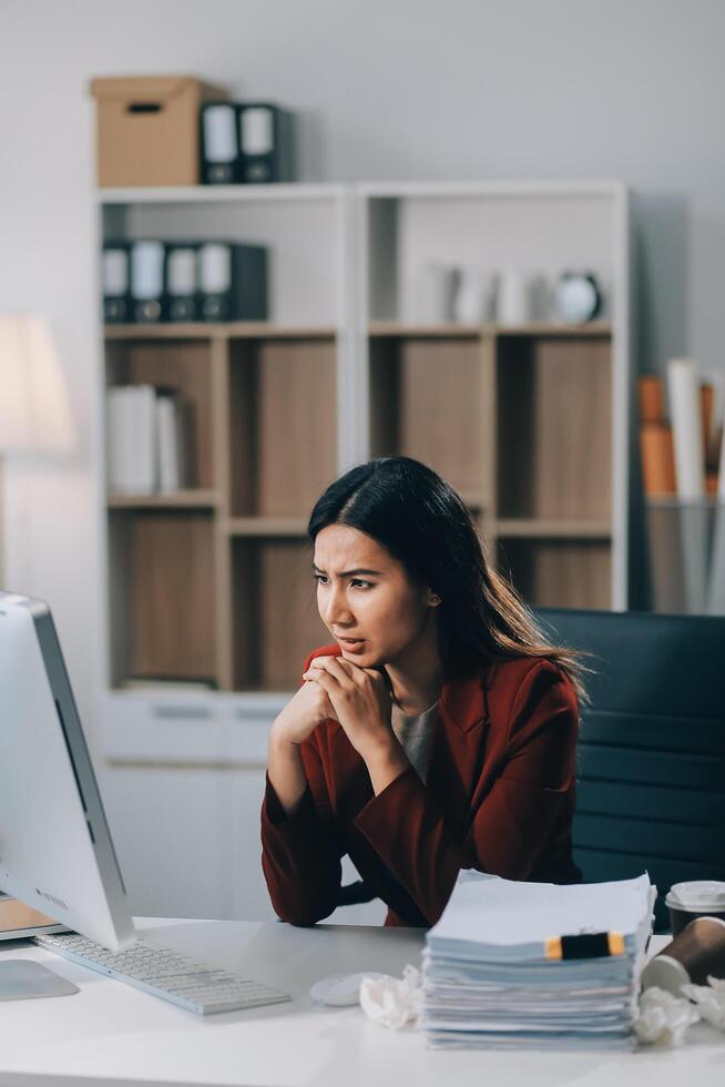 Young asian business woman with tired eyes and headache photo
