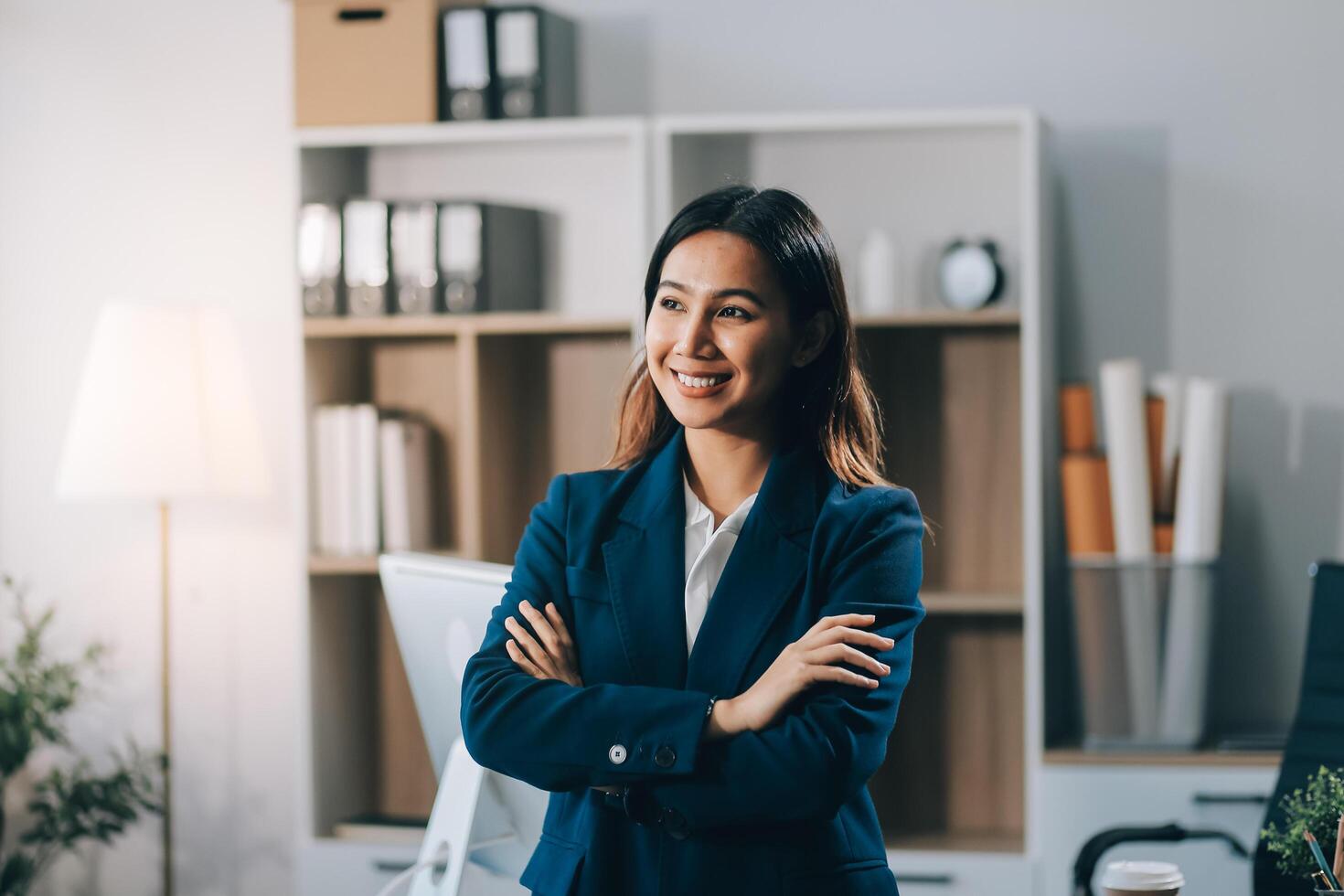 Portrait of Happy young Asian businesswoman looking at camera,arms crossed folded.Smiling woman executive manager,secretary offering professional business services standing in office. photo